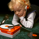 A child listening to music recorded on Teenage Engineering's new PO-80 Record Factory.